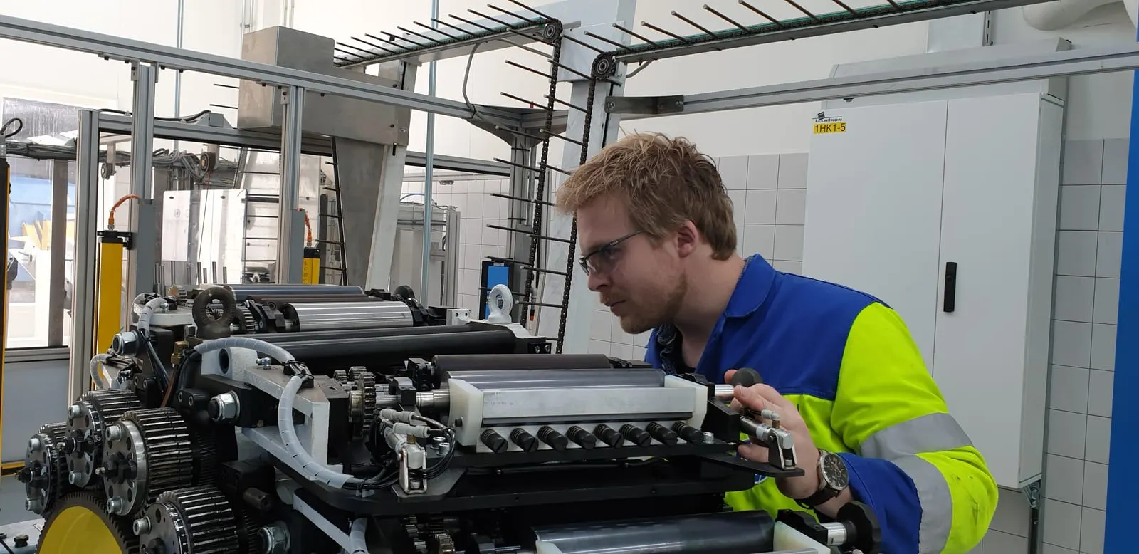Monteur werkt aan de besturing van een bestaande productiemachine.