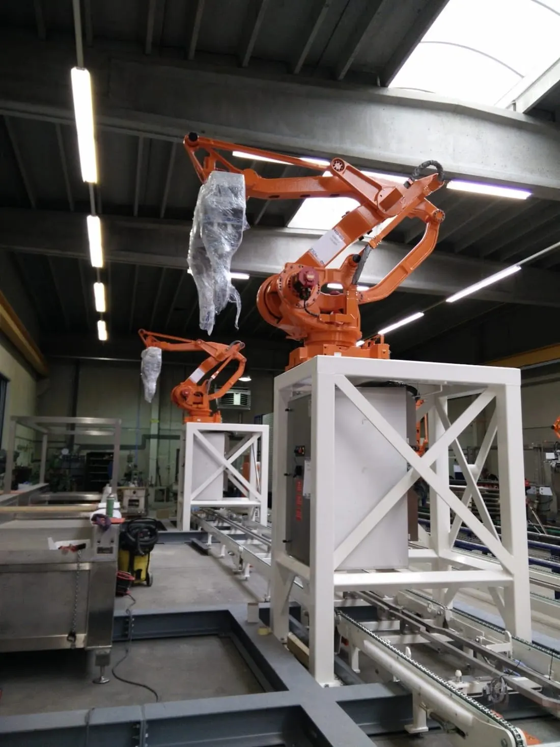 Twee palletiseerrobots op stellingen tijdens de opbouw.